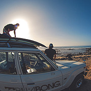 Cargue tablas de surf para el curso de surf desde el techo del automóvil