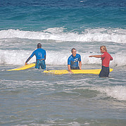 El instructor de surf explica la posición correcta en la tabla de surf